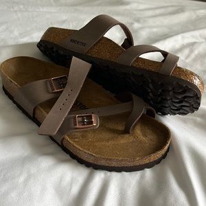 This pair of sandals is a Birkenstock size 10. Came defected w/spot on inside